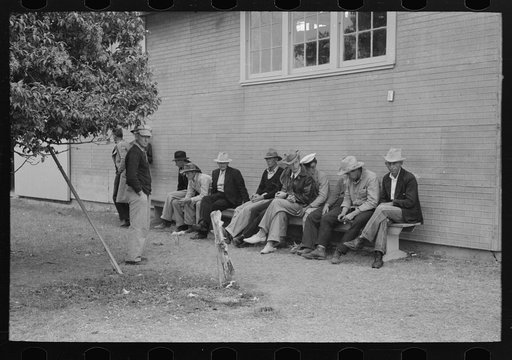 Men sitting on a bench at county fair, Gonzales, Texas