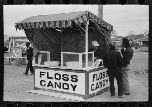 Untitled photo, possibly related to: Popcorn man and his wife studying the map, county fair, Gonzales, Texas