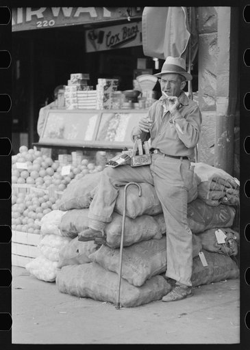 Untitled photo, possibly related to: Street vendor rolling cigarette, market square, Waco, Texas