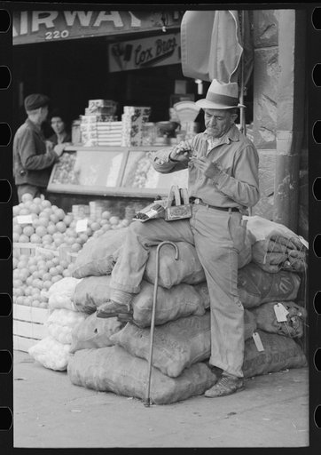 Street vendor rolling cigarette, market square, Waco, Texas