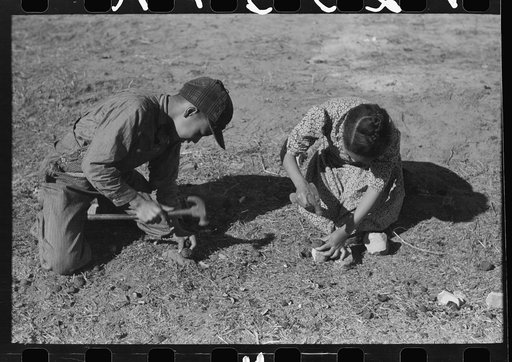 Children of Pomp Hall, Negro tenant farmer, cracking black walnuts which were grown on the farm, Creek County, Oklahoma. See general caption number 23