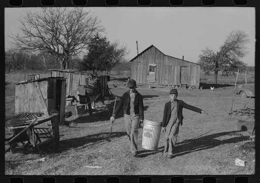 Son of Pomp Hall, Negro tenant farmer, carrying can full of mash to hogpen, Creek County, Oklahoma. See general caption, number 23