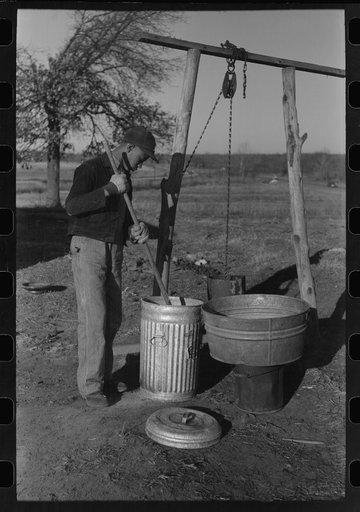 Untitled photo, possibly related to: Son of Pomp Hall, Negro tenant farmer, carrying can full of mash to hogpen, Creek County, Oklahoma. See general caption, number 23