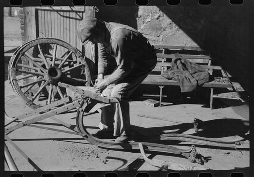 Untitled photo, possibly related to: Blacksmith's helper disassembling plow belonging to Pomp Hall, Negro tenant farmer from Creek County, Oklahoma. Blacksmith shop is in Depew, Oklahoma. See general caption number 23