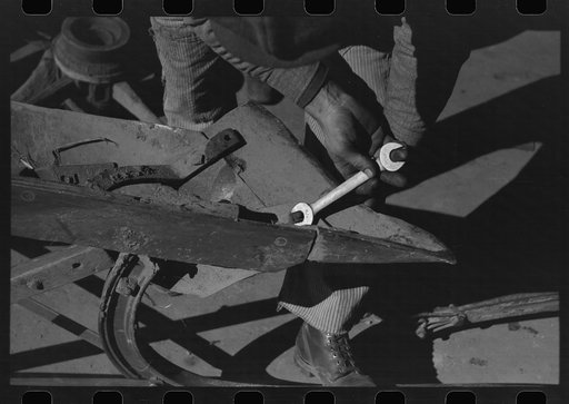 Blacksmith's helper disassembling plow belonging to Pomp Hall, Negro tenant farmer from Creek County, Oklahoma. Blacksmith shop is in Depew, Oklahoma. See general caption number 23