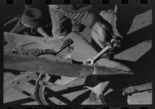 Untitled photo, possibly related to: Blacksmith's helper disassembling plow belonging to Pomp Hall, Negro tenant farmer from Creek County, Oklahoma. Blacksmith shop is in Depew, Oklahoma. See general caption number 23