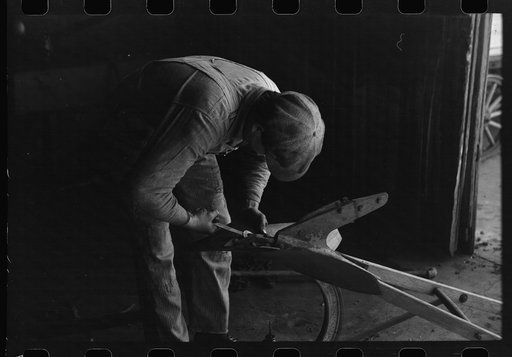 Untitled photo, possibly related to: Blacksmith's helper disassembling plow belonging to Pomp Hall, Negro tenant farmer from Creek County, Oklahoma. Blacksmith shop is in Depew, Oklahoma. See general caption number 23