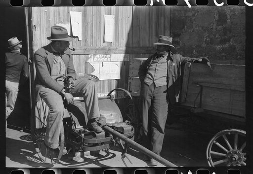 Pomp Hall, Negro tenant farmer, talking to another farmer as he waits at the blacksmith shop in Depew, Oklahoma for his plow points to be sharpened. Pomp Hall is considered one of the best farmers in this county and is consulted by Negroes and whites concerning farming problems. See general caption 