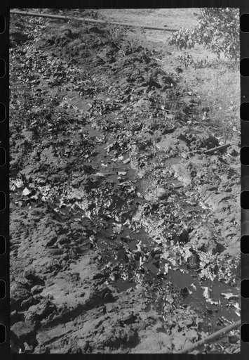 Untitled photo, possibly related to: Stream of waste oil flowing from tanks to slush pits across the open field, Creek County, Oklahoma