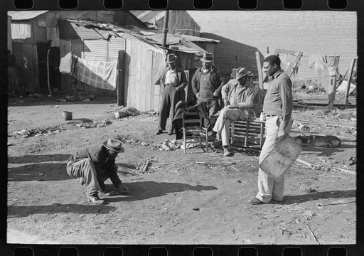 Negro playing marbles on the first warm day in the spring. In this game the players shoot from hole to hole, the same idea as in golf or miniature golf. Eufaula, Oklahoma