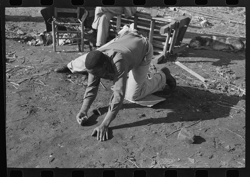 Untitled photo, possibly related to: Negro playing marbles on the first warm day in the spring. In this game the players shoot from hole to hole, the same idea as in golf or miniature golf. Eufaula, Oklahoma