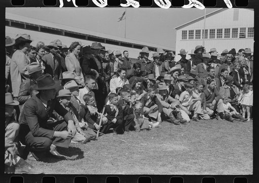 Group of spectators at sideshow watching man unloosen himself from chains.  San Angelo Fat Stock Show, San Angelo, Texas