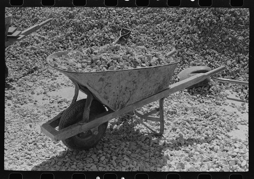 Wheelbarrow loaded with crushed rock to be used in bridge construction in Menard County, Texas