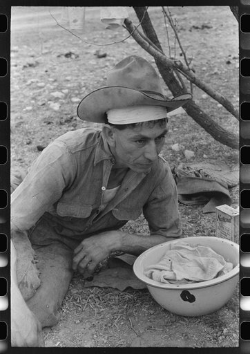 Professional migratory sheep and goat shearer resting after noonday meal on ranch of rehabilitation borrower in Kimble County, Texas