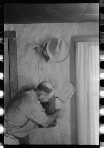 Untitled photo, possibly related to: West Texas ranchman making a telephone call, Kimble County, Texas