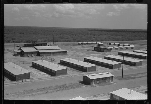 Row shelters in foreground, isolation units in right background, community house in left background, migratory labor camp, Sinton, Texas