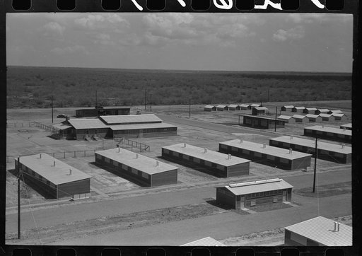 Untitled photo, possibly related to: Row shelters in foreground, isolation units in right background, community house in left background, migratory labor camp, Sinton, Texas