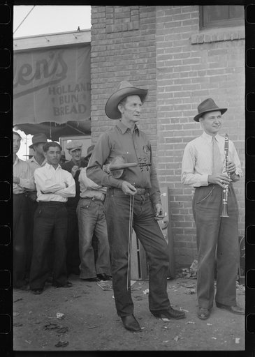 Untitled photo, possibly related to: Member of orchestra which plays outside grocery store on Saturday afternoon tuning his violin, Phoenix, Arizona