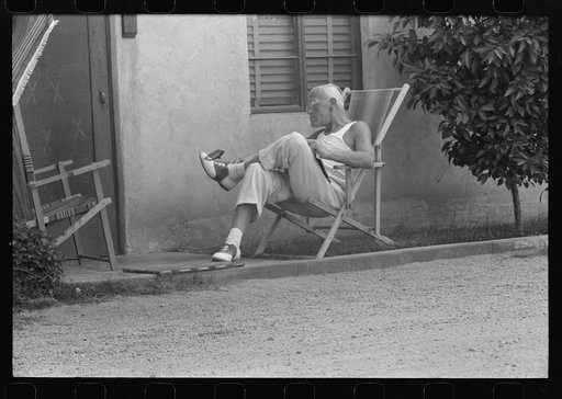 Sun bather swatting fly, tourist court at Phoenix, Arizona