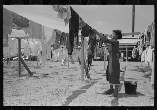 Wife of migratory worker hanging up laundry at the Agua Fria Migratory Labor Camp, Arizona