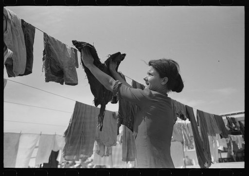 Untitled photo, possibly related to: Wife of migratory worker hanging up laundry at the Agua Fria Migratory Labor Camp, Arizona