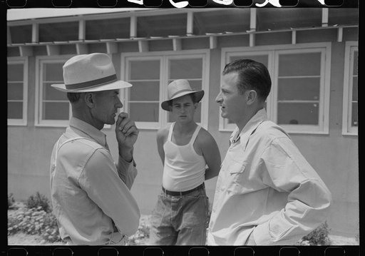 Migratory laborer at left talking to the camp manager, right, at the Agua Fria Migratory Labor Camp, Arizona