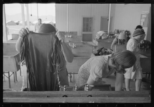 Untitled photo, possibly related to: Wives of migratory laborers washing their family laundry at the Agua Fria Migratory Labor Camp, Arizona. The difference in the personal appearance of the migratory workers when hot water and laundry facilities are available is striking and indicates that hard wor