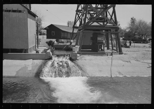 Untitled photo, possibly related to: Woman washing clothes at deep well which also feeds the irrigation ditch, Maricopa County, Arizona. This water comes out of the ground hot enough for laundry purposes