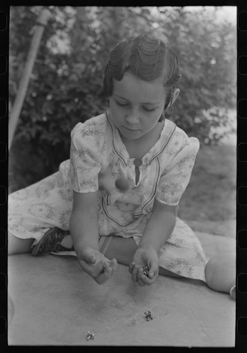 Little girl playing jacks at the Casa Grande Valley Farms, Pinal County, Arizona