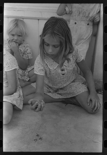Little girl playing jacks at the Casa Grande Valley Farms, Pinal County, Arizona