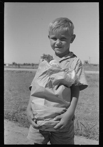 Little boy with sack of vegetables from the community garden at the Casa Grande Valley Farms, Pinal County, Arizona