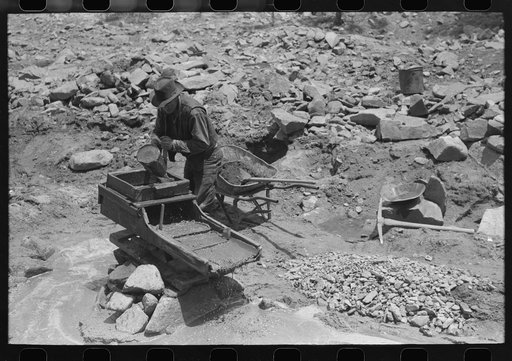 Gold prospector pouring water into "rocker," Pinos Altos, New Mexico