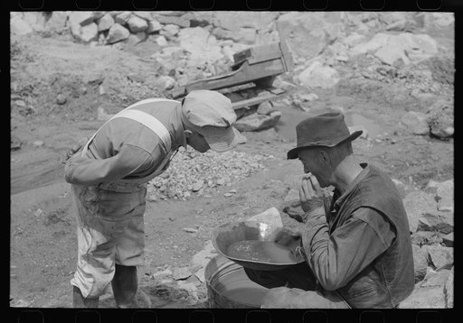 Untitled photo, possibly related to: Miner on right examining a "pan" while the visiting prospector watches. Pinos Altos, New Mexico