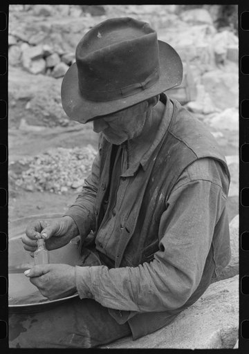 Untitled photo, possibly related to: Gold prospector putting flakes of gold which he has recovered through wet washing and panning into bottle. Pinos Altos, New Mexico