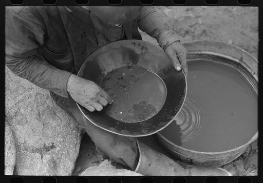 "Pan" of gold. The curving light line across the center of the pan is tiny particles of gold. Pinos Altos, New Mexico