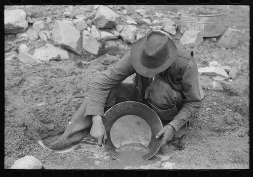 Prospector washing a "pan" of gold-bearing dirt. Pinos Altos, New Mexico