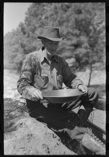 Untitled photo, possibly related to: Prospector panning gold by dry method. Pinos Altos, New Mexico