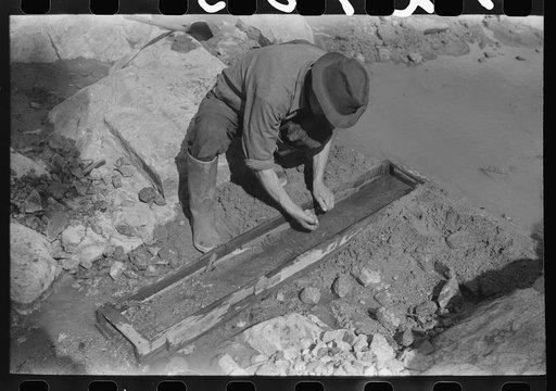 Prospector working the sluice box. Pinos Altos, New Mexico