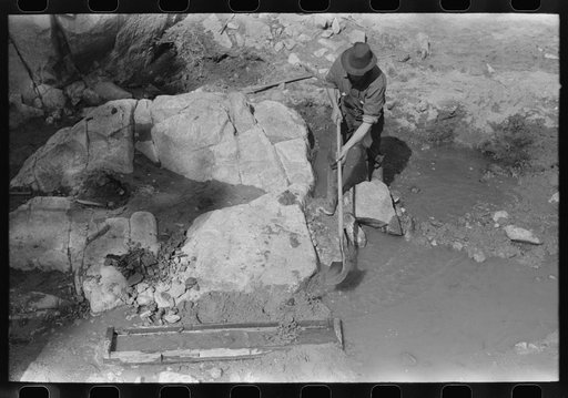 Prospector working the sluice box. Pinos Altos, New Mexico