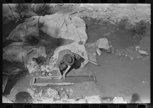 Prospector working the sluice box. Pinos Altos, New Mexico