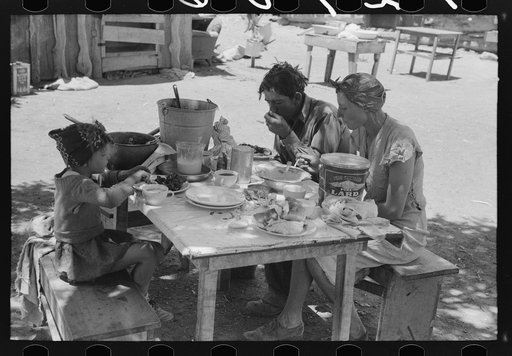 The Caudill family eating dinner in the open the day they were moving their dugout. Pie Town, New Mexico