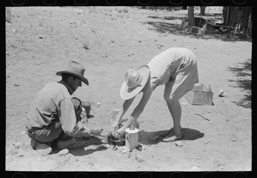 Faro and Doris Caudill cooking dinner over camp fire, Pie Town, New Mexico