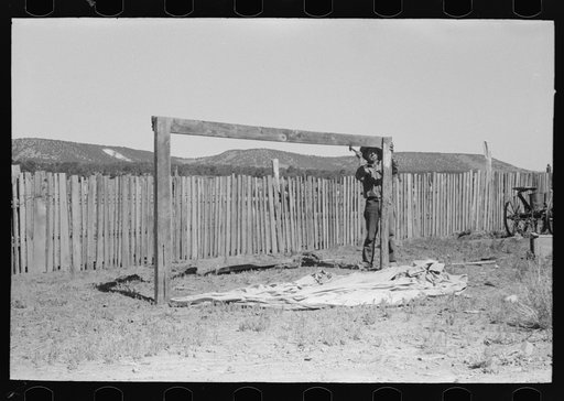 Faro Caudill putting up the center support of his tent. Pie Town, New Mexico