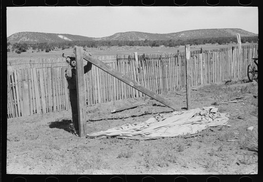 Faro Caudill putting up the center support of his tent. Pie Town, New Mexico