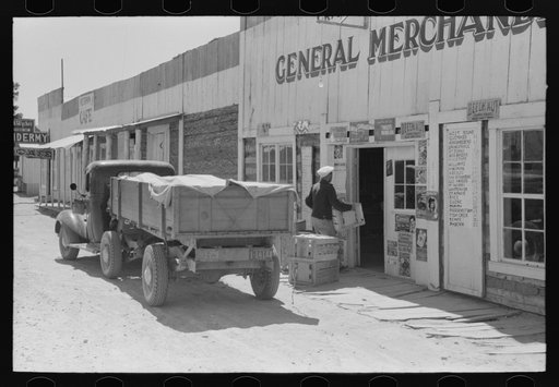 Vegetable and fruit trucker in front of general store, Pie Town, New Mexico. Grapefruit which he brings in is from Arizona