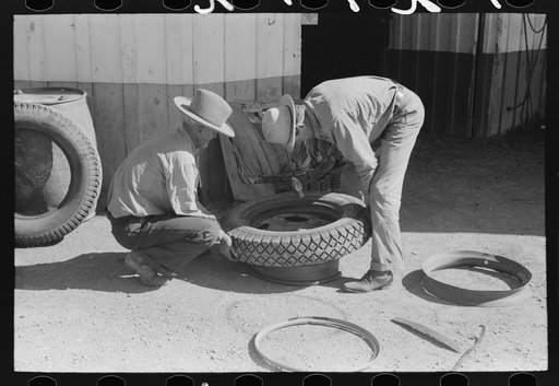 Untitled photo, possibly related to: Changing tire at the garage. Pie Town, New Mexico
