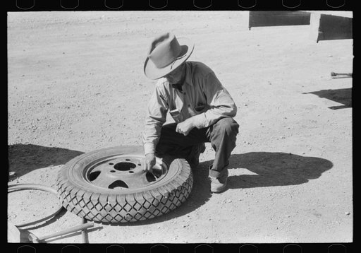 Untitled photo, possibly related to: Changing tire at the garage. Pie Town, New Mexico