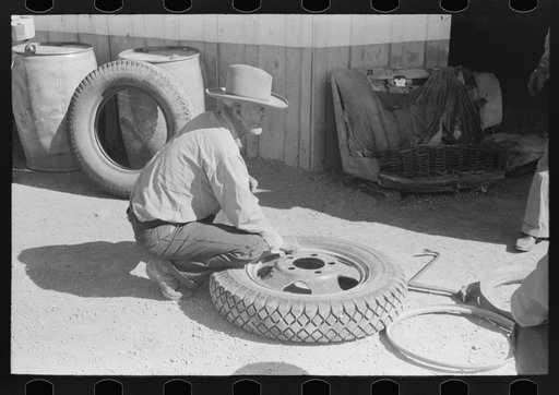 Untitled photo, possibly related to: Changing tire at the garage. Pie Town, New Mexico