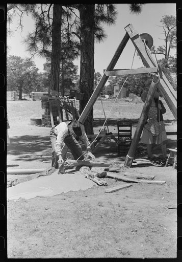 Untitled photo, possibly related to: Farmer emptying slush from well which he is drilling with cable tools. Pie Town, New Mexico