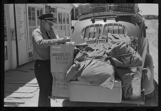 Stage driver making out express receipt in front of general store, Pie Town, New Mexico